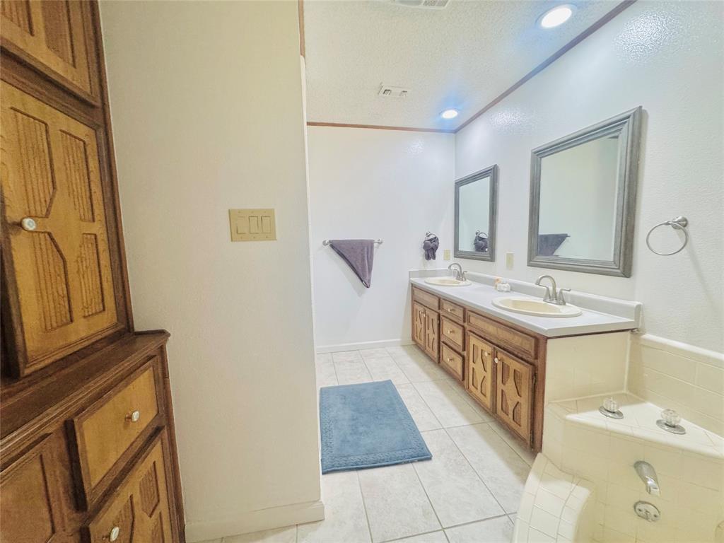 1109 Simpson Terrace Bedford, TX 76021 - Photo 29 of 39 a bathroom with a sink a mirror and a bathtub