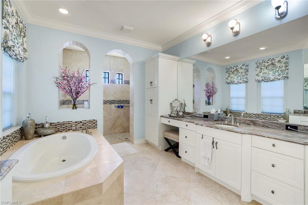 7304 Hagen Way Naples, FL 34113 - Photo 14 of 37 Bathroom featuring vanity, a walk in shower, ornamental molding, and a garden tub