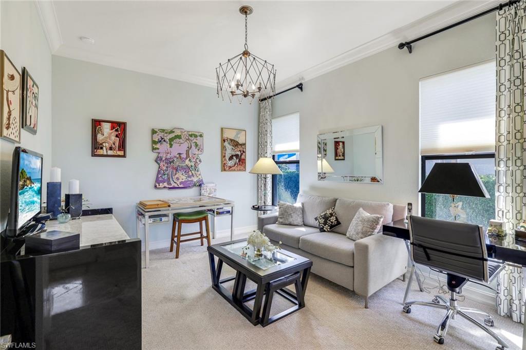 7304 Hagen Way Naples, FL 34113 - Photo 21 of 37 Living area with a notable chandelier, crown molding, baseboards, and light carpet