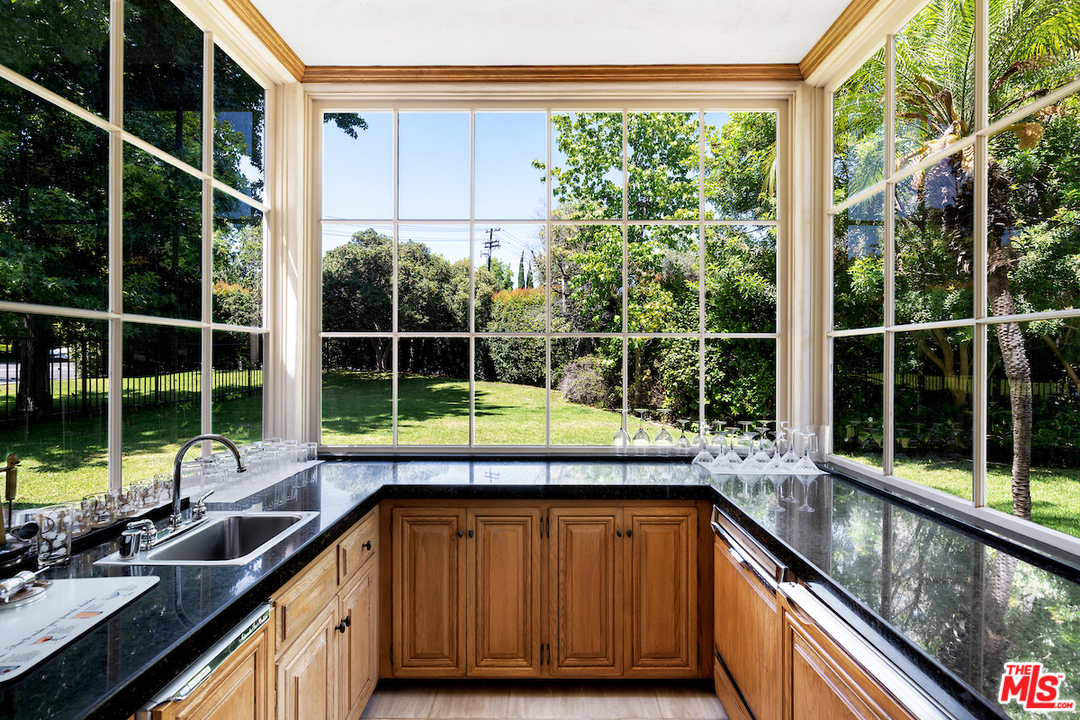 300 South Rockingham Avenue Los Angeles, CA 90049 - Photo 17 of 49 a kitchen with furniture a window and a sink