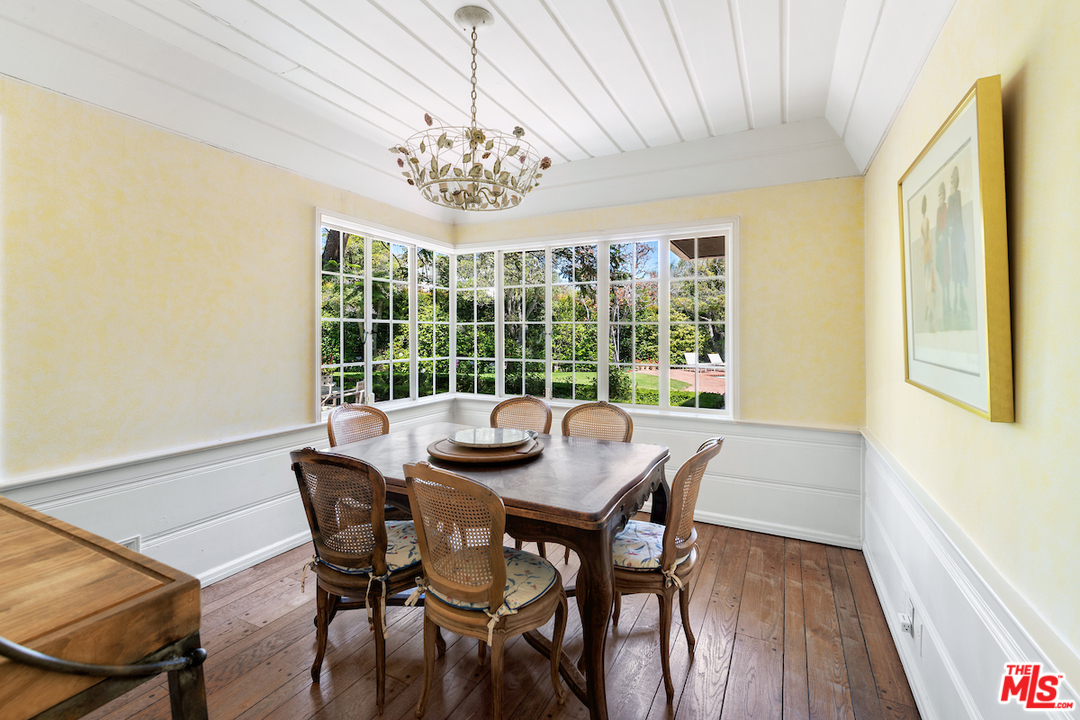 300 South Rockingham Avenue Los Angeles, CA 90049 - Photo 20 of 49 a view of a dining room with furniture a chandelier and wooden floor