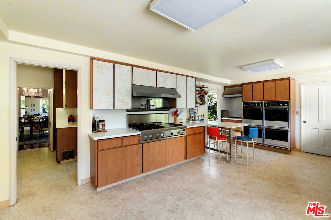 300 South Rockingham Avenue Los Angeles, CA 90049 - Photo 21 of 49 a kitchen with stainless steel appliances a stove and cabinets