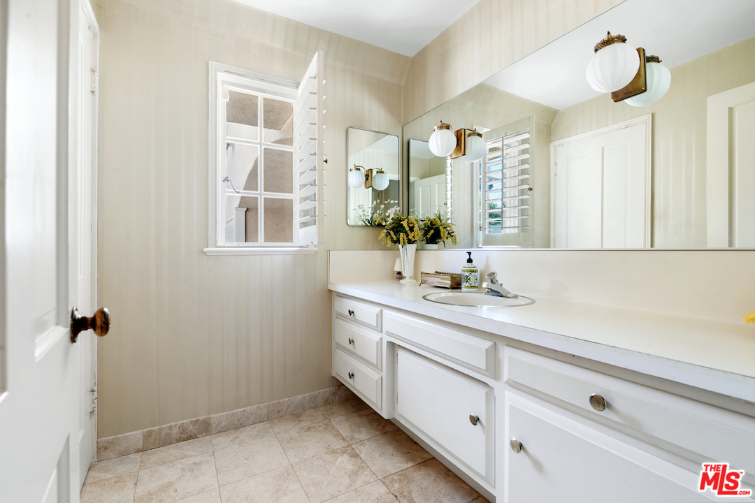300 South Rockingham Avenue Los Angeles, CA 90049 - Photo 23 of 49 a living room with furniture a flat screen tv and a fireplace