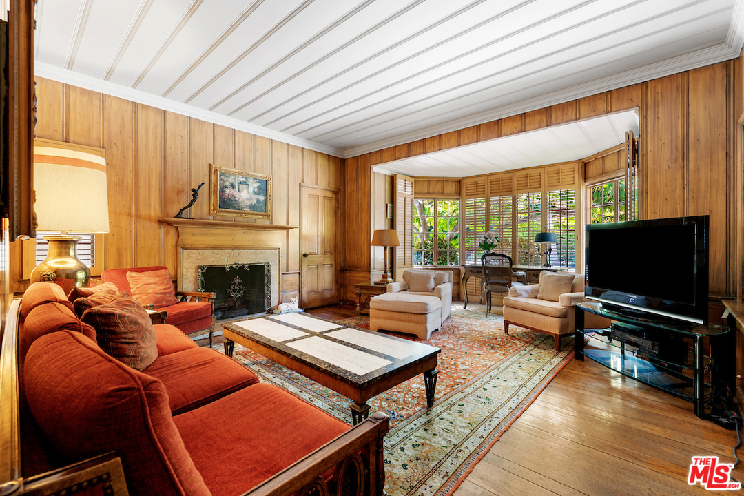 300 South Rockingham Avenue Los Angeles, CA 90049 - Photo 24 of 49 a living room with furniture a flat screen tv and a fireplace