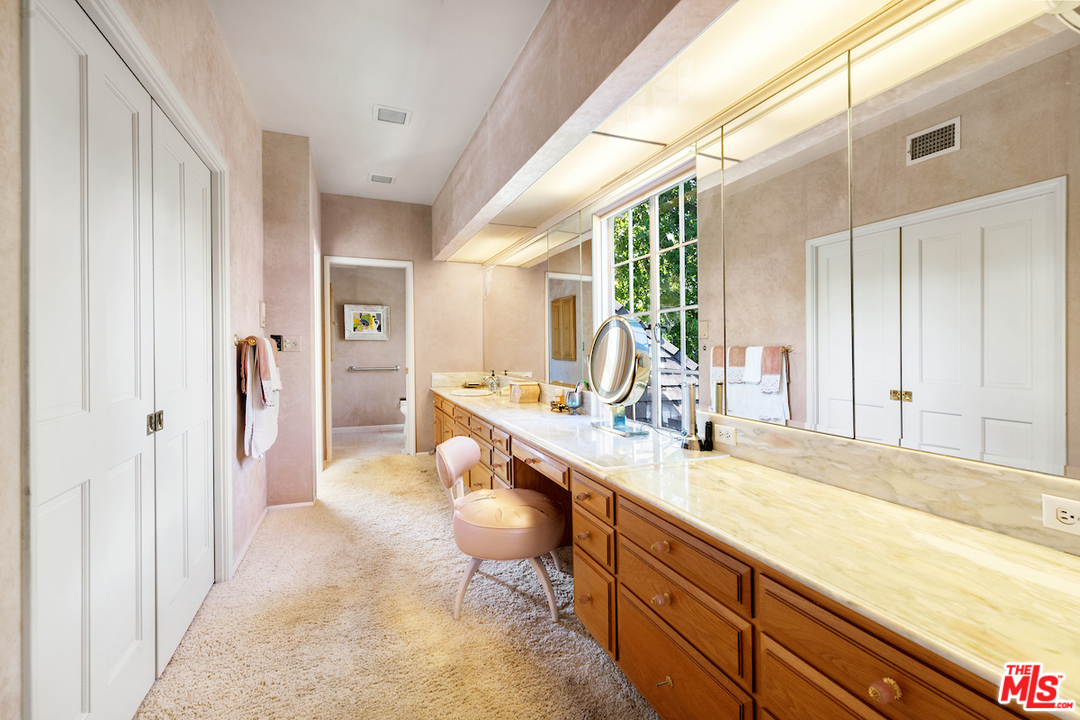 300 South Rockingham Avenue Los Angeles, CA 90049 - Photo 35 of 49 a spacious bathroom with a double vanity sink a mirror and a shower