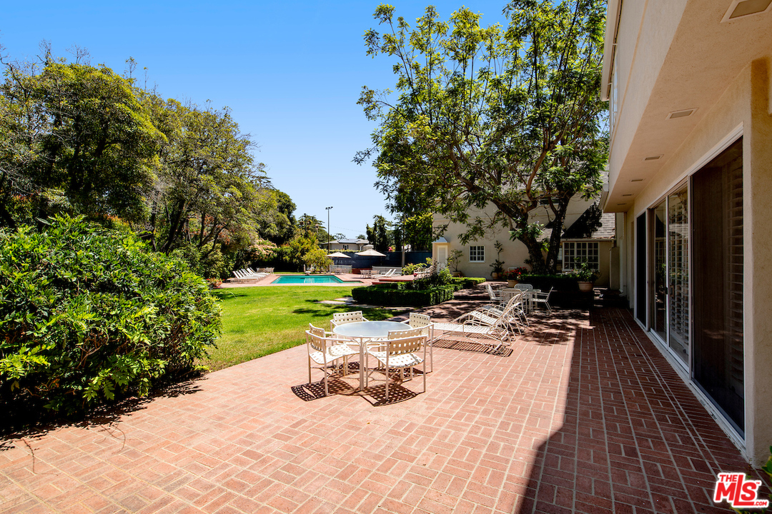 300 South Rockingham Avenue Los Angeles, CA 90049 - Photo 41 of 49 a swimming pool with barbeque oven outdoor seating and yard