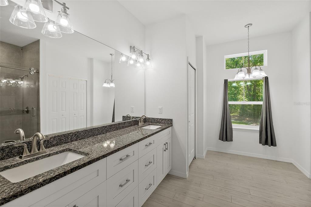 1370 Buckles Road Pierson, FL 32180 - Photo 20 of 57 a spacious bathroom with a granite countertop double vanity sink a mirror and a shower