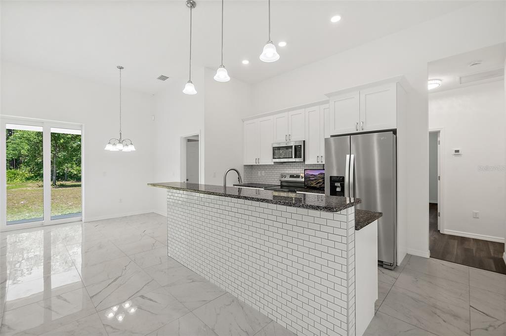 1370 Buckles Road Pierson, FL 32180 - Photo 7 of 57 a kitchen with stainless steel appliances a refrigerator sink and microwave