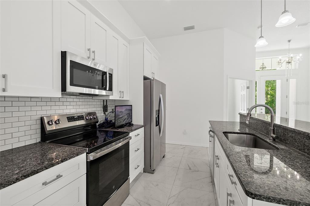 1370 Buckles Road Pierson, FL 32180 - Photo 8 of 57 a kitchen with granite countertop a sink a stove and refrigerator