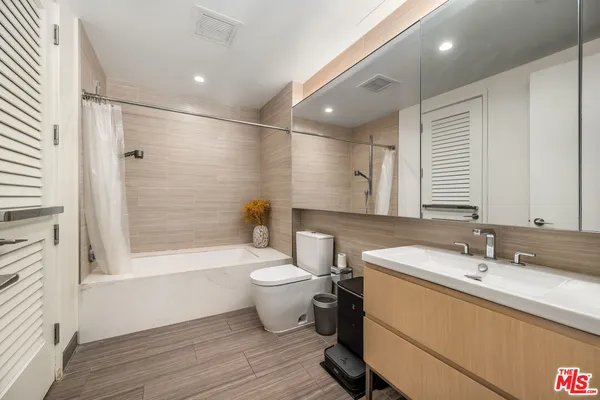 a bathroom with a double vanity sink toilet and shower