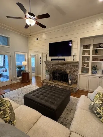 a kitchen with stainless steel appliances kitchen island granite countertop a stove a sink a refrigerator and white cabinets with wooden floor