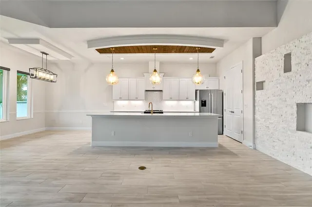 a large kitchen with stainless steel appliances kitchen island granite countertop a sink and cabinets