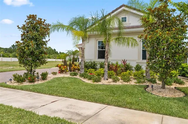 a front view of a house with a garden and yard