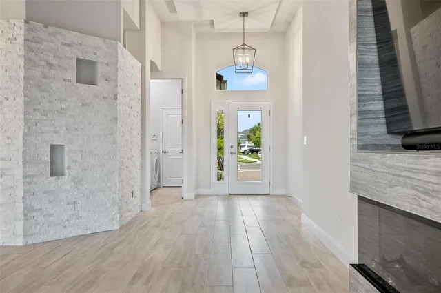 a view of a hallway with wooden floor and windows