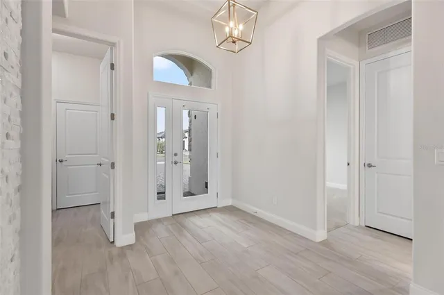 a large white kitchen with wooden floors and stainless steel appliances