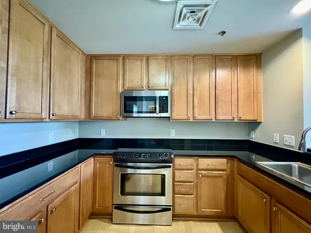 a kitchen with granite countertop a stove and a sink
