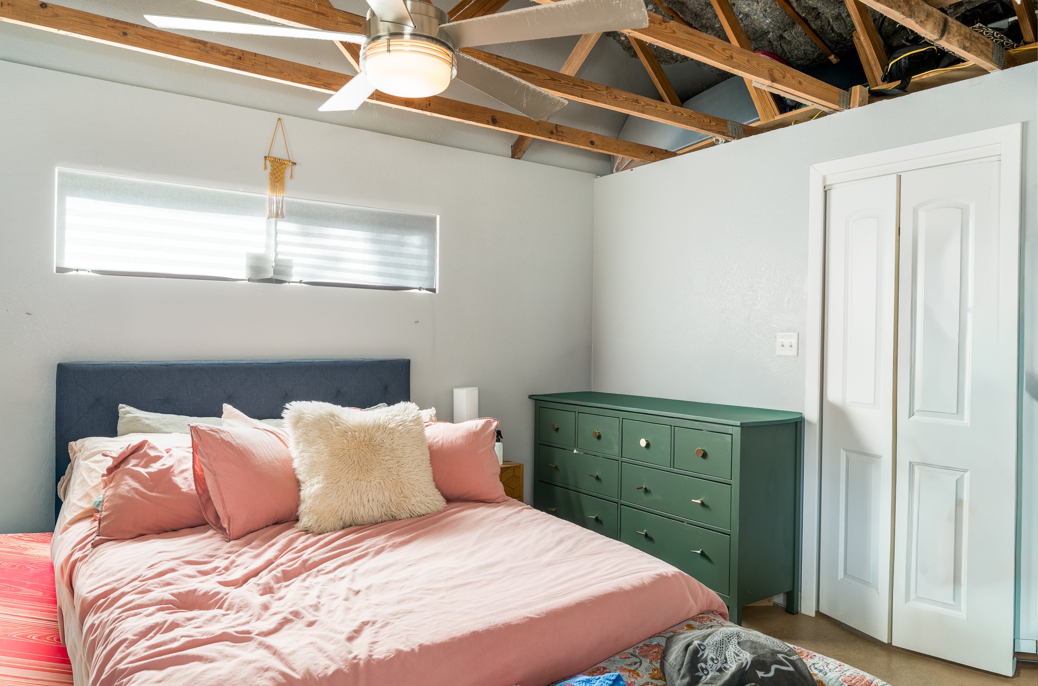 701 Vargas Road Austin, TX 78741 - Photo 9 of 13 Exposed wood rafters add rustic character to this bedroom featuring a high horizontal window.