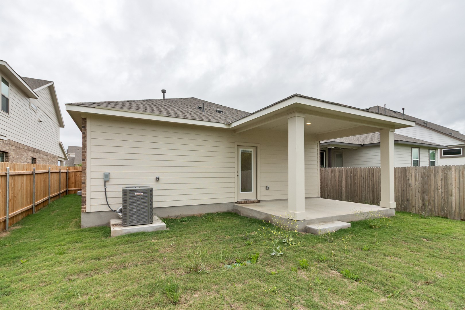 18605 Emu Lane Manor, TX 78653 - Photo 26 of 27 The property features a covered patio with pillars, a door with a glass pane, and a fenced yard