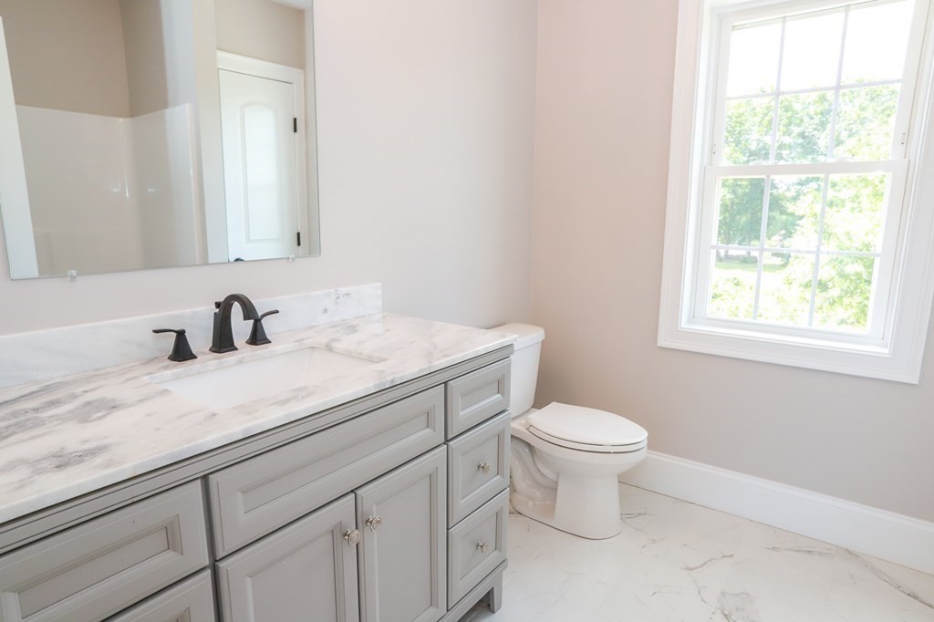 7 Ayer Road Littleton, MA 01460 - Photo 25 of 39 a bathroom with a granite countertop sink a toilet and a window