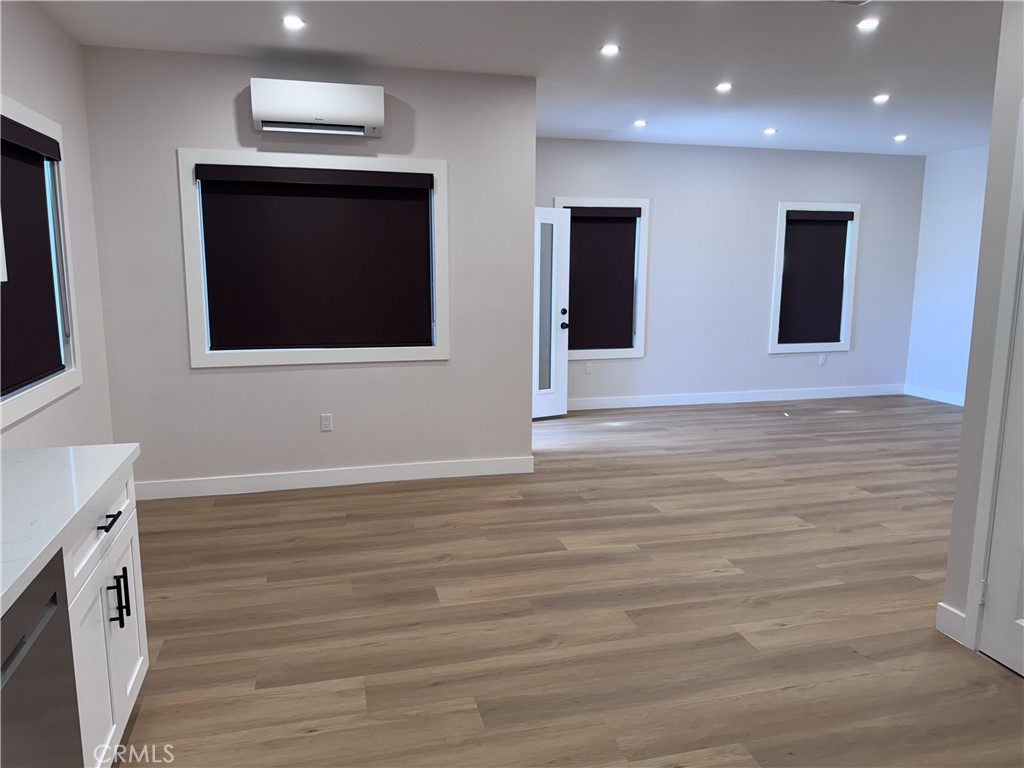 13431 Goldenwest Street Westminster, CA 92683 - Photo 13 of 23 a view of an empty room with wooden floor and windows