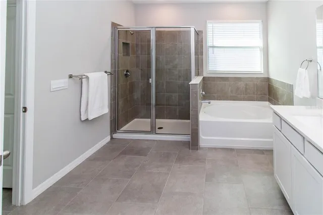 a bathroom with a tub shower and window