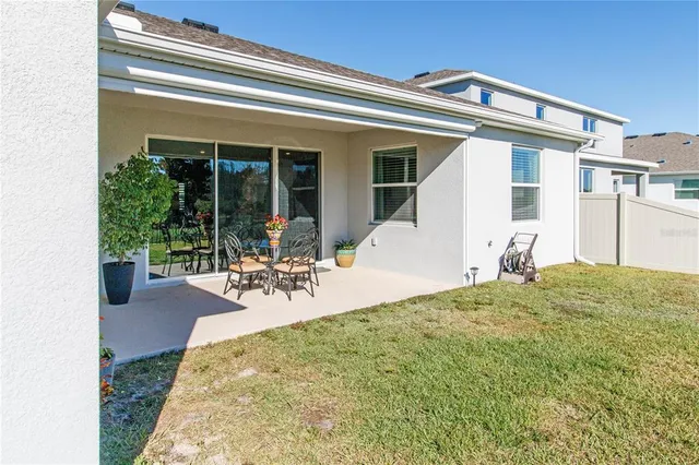 a view of a patio with table and chairs and potted plants