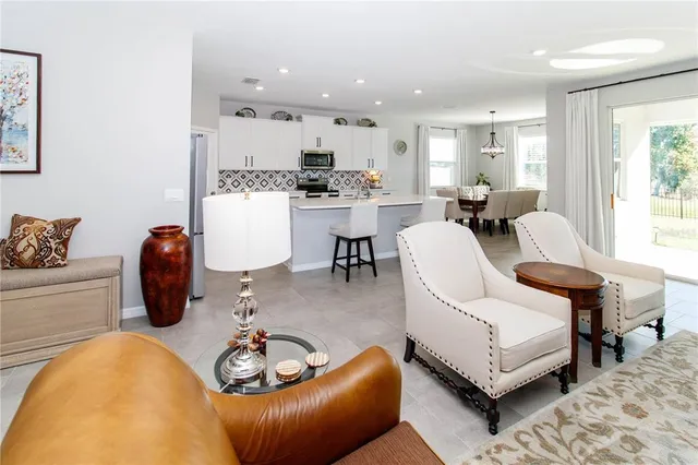a living room with furniture and kitchen view