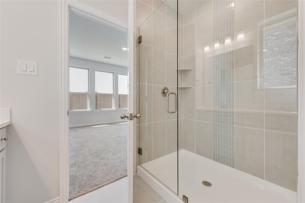 4136 Tarlton Road Little Elm, TX 75068 - Photo 24 of 28 a bathroom with a glass shower door