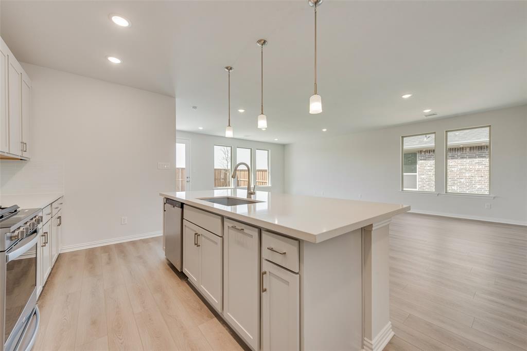 4136 Tarlton Road Little Elm, TX 75068 - Photo 8 of 28 a kitchen with kitchen island a sink appliances and a counter space