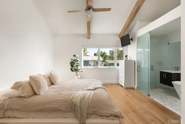 a bedroom with a large bed and a chandelier fan
