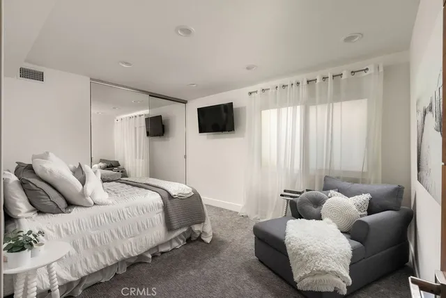 a bedroom with bed and a flat screen tv