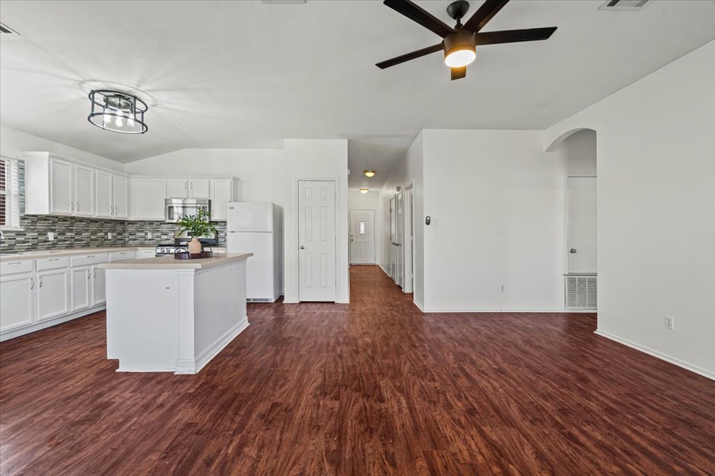 17912 Aleppo Pine Elgin, TX 78621 - Photo 9 of 30 Kitchen with white cabinets, stainless steel appliances, light countertops, dark wood-style floors, and vaulted ceiling