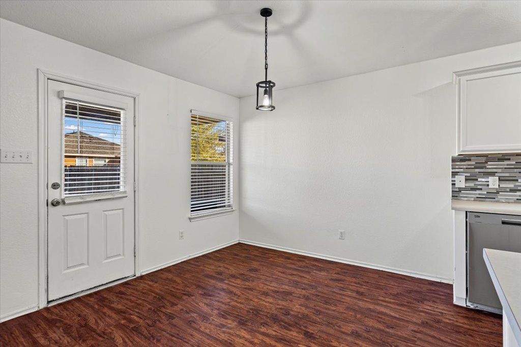 17912 Aleppo Pine Elgin, TX 78621 - Photo 12 of 30 Unfurnished dining area with dark wood-style flooring and baseboards