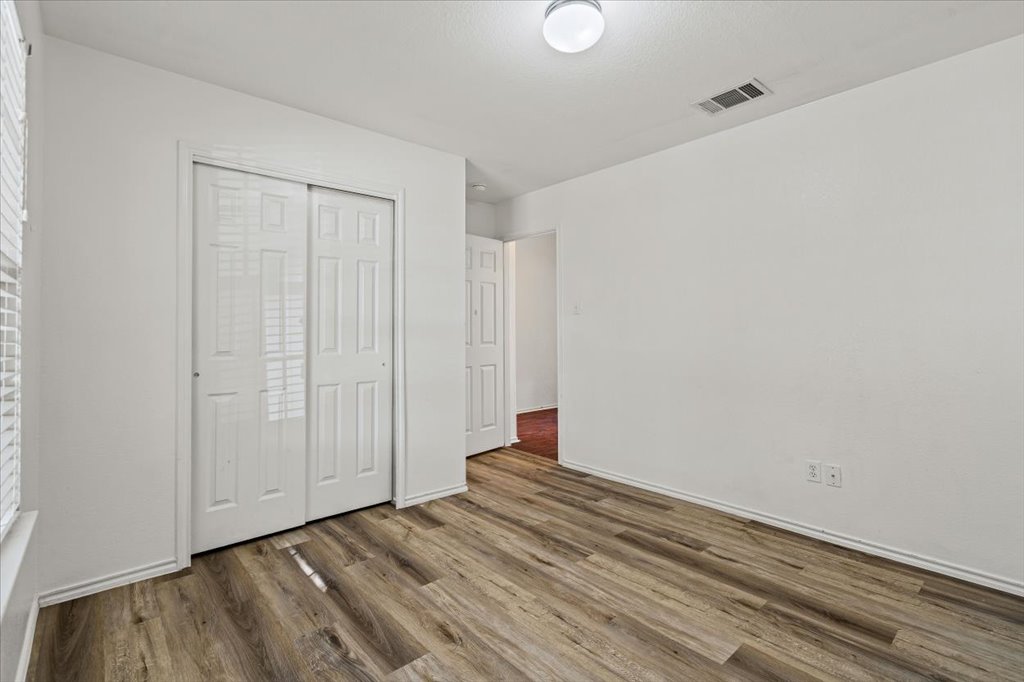 17912 Aleppo Pine Elgin, TX 78621 - Photo 19 of 30 Unfurnished bedroom with a closet and wood finished floors