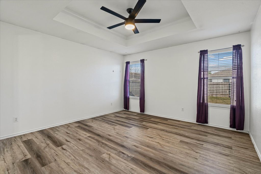 17912 Aleppo Pine Elgin, TX 78621 - Photo 4 of 30 Spare room with wood finished floors, ceiling fan, a tray ceiling, and crown molding