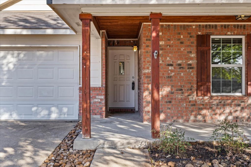 17912 Aleppo Pine Elgin, TX 78621 - Photo 6 of 30 Property entrance with a porch, brick siding, a garage, and concrete driveway