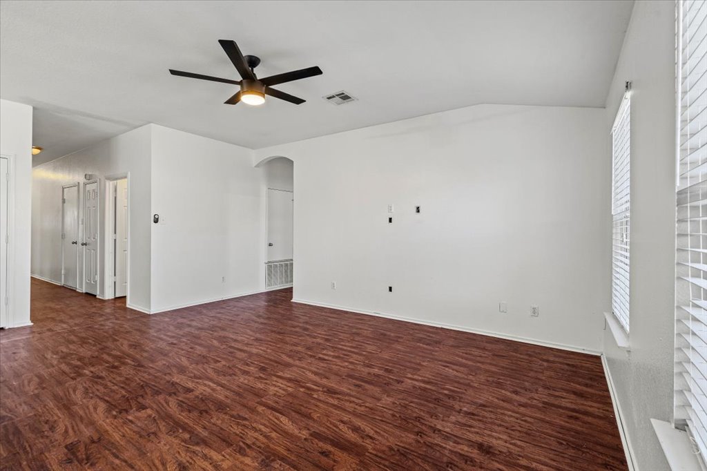 17912 Aleppo Pine Elgin, TX 78621 - Photo 8 of 30 Empty room with arched walkways, dark wood-style floors, lofted ceiling, and a ceiling fan