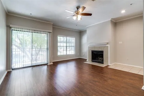 wooden floor fireplace and windows in an empty room