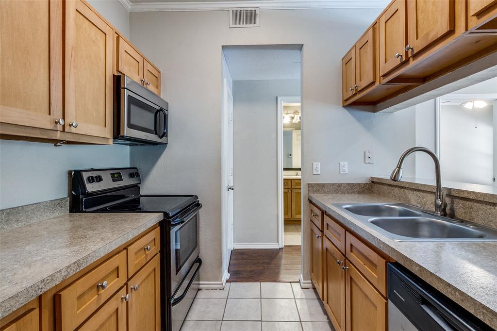 6003 Oram Street, Unit 104 Dallas, TX 75206 - Photo 9 of 23 a kitchen with stainless steel appliances granite countertop a sink a stove and cabinets