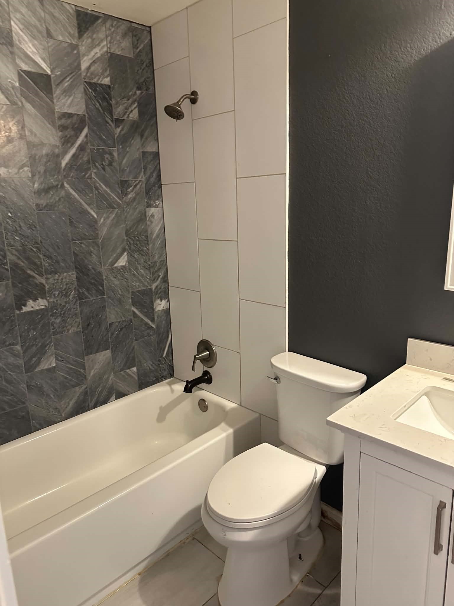 18312 Crestwind Lane Elgin, TX 78621 - Photo 8 of 15 Elegant gray and white tile work elevates this contemporary full bathroom.