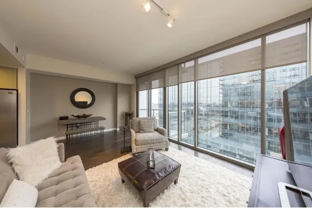 a living room with furniture and a floor to ceiling window