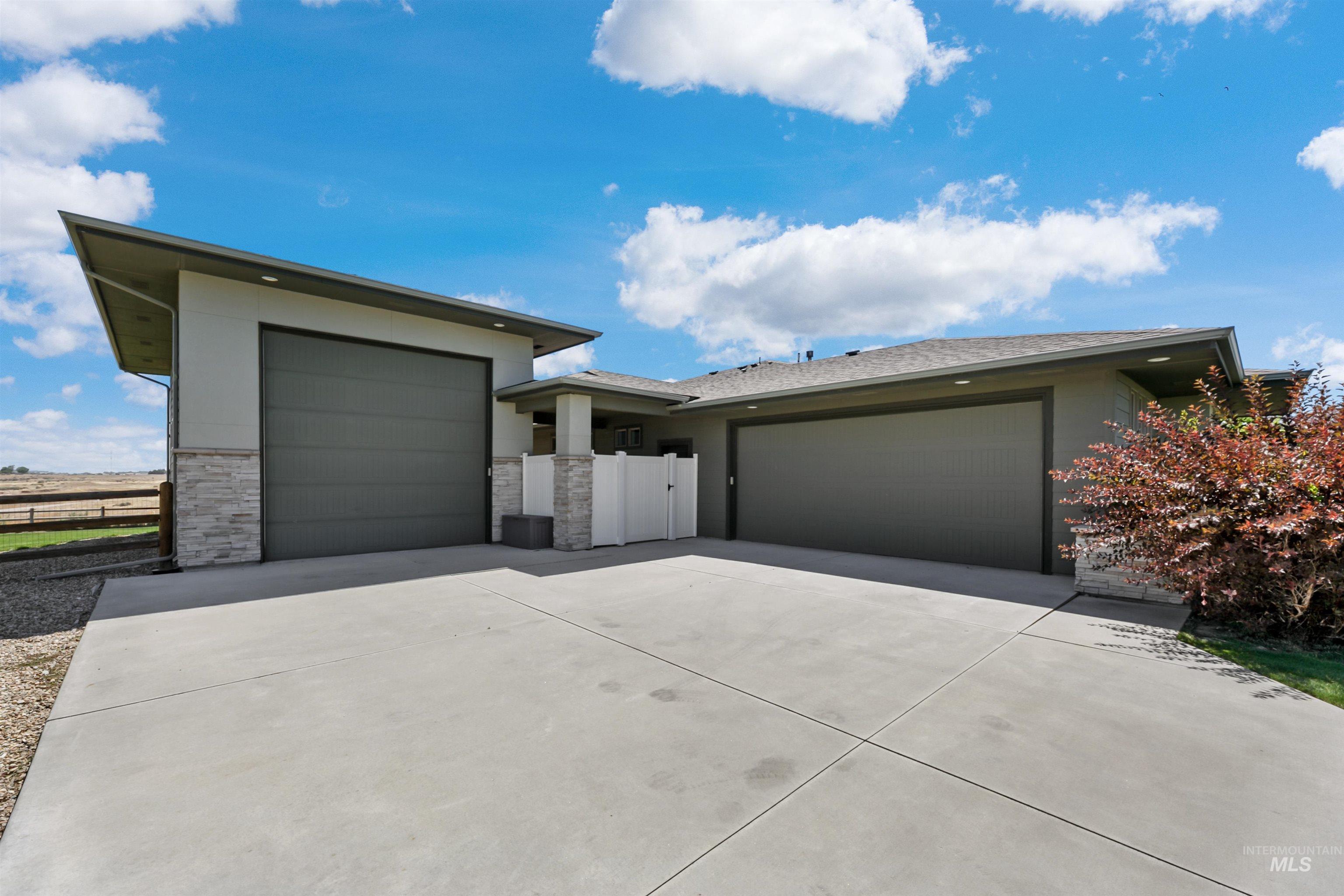 24398 Tombstone Ridge Court Middleton, ID 83644 - Photo 5 of 47 Spacious concrete driveway accommodating multiple vehicles, flanked by two attached garages with horizontal panel doors