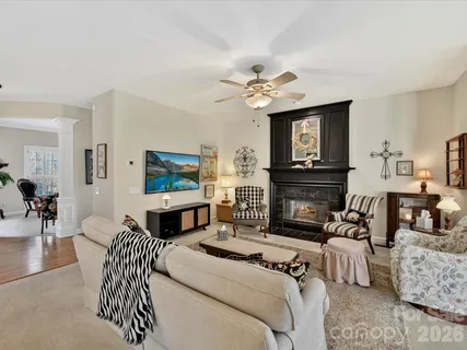 a bedroom with a bed a couches a fireplace and a flat screen tv