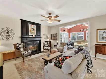 a living room with furniture a fireplace and a large window