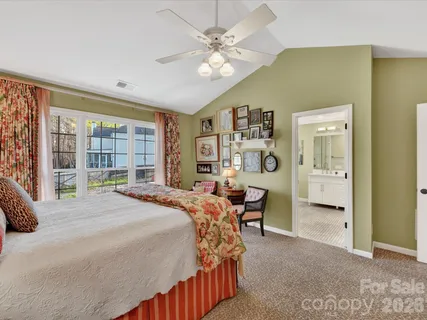 a bedroom with a bed dresser and a large window