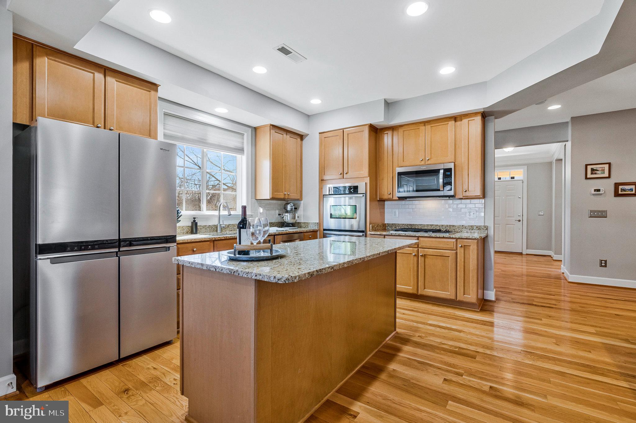 41008 Indigo Place Leesburg, VA 20175 - Photo 15 of 59 a kitchen with kitchen island granite countertop appliances a sink and cabinets