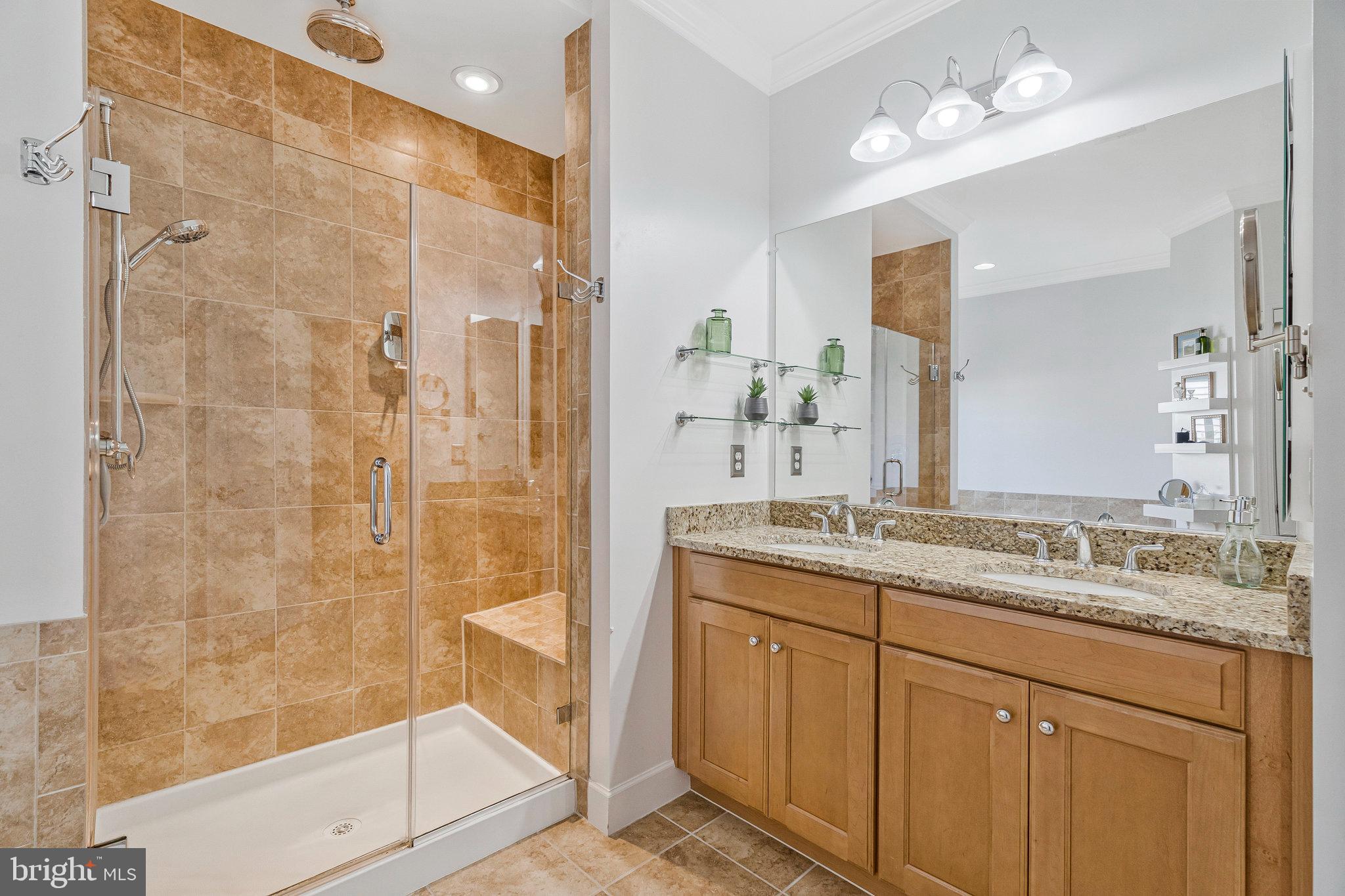 41008 Indigo Place Leesburg, VA 20175 - Photo 24 of 59 a bathroom with a granite countertop sink a mirror and a shower