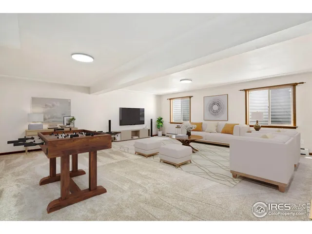 a view of an empty room with wooden floor and stairs