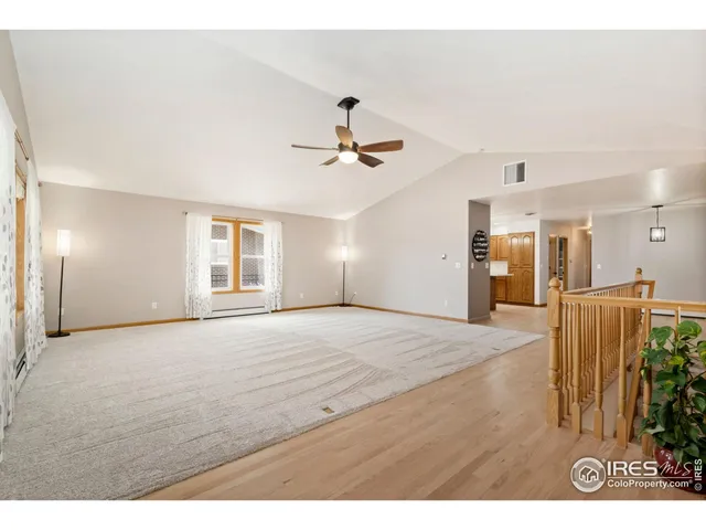 a view of a livingroom with a furniture chandelier fan and a hardwood floor
