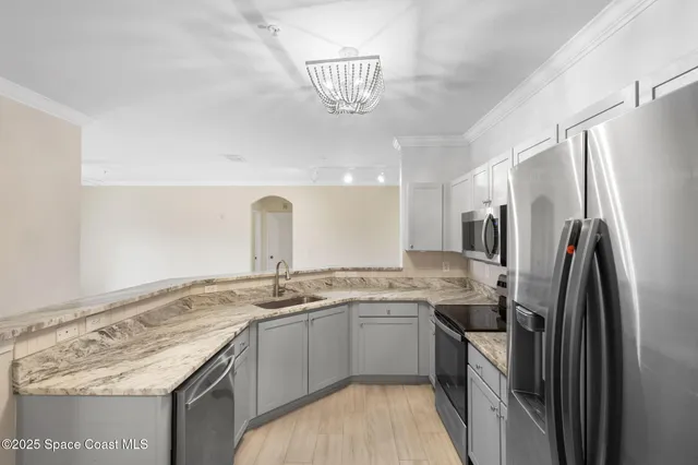 a kitchen with stainless steel appliances granite countertop a refrigerator a stove a sink and a refrigerator